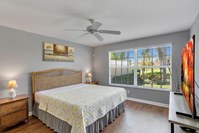 bedroom featuring a textured ceiling, dark hardwood / wood-style floors, and ceiling fan