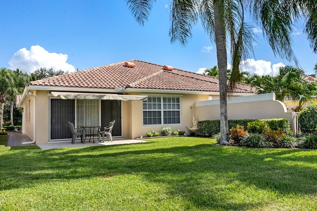 rear view of house with a yard and a patio area