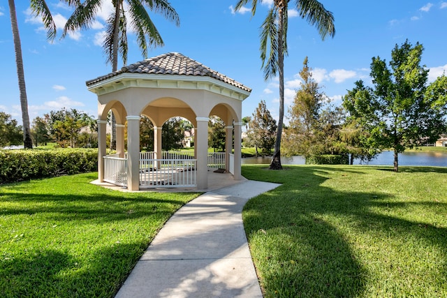 view of property's community with a water view, a patio, and a lawn