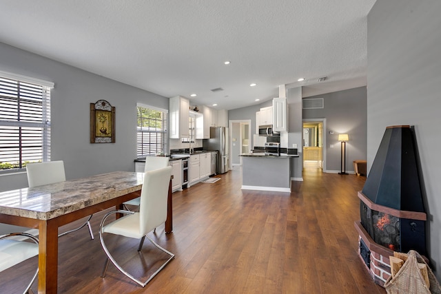 dining area featuring sink, a textured ceiling, and dark hardwood / wood-style floors