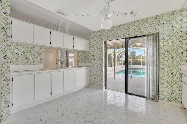 unfurnished dining area with ceiling fan and light tile patterned floors