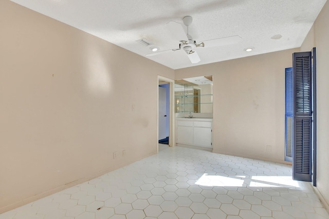 unfurnished room featuring ceiling fan, a textured ceiling, and tile patterned flooring