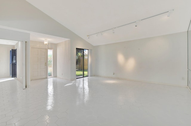 spare room featuring light tile patterned flooring, track lighting, and high vaulted ceiling