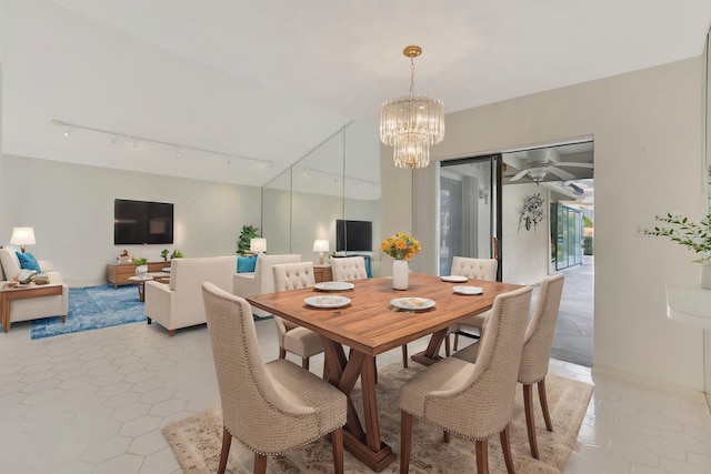 dining space featuring light tile patterned flooring, track lighting, and a chandelier