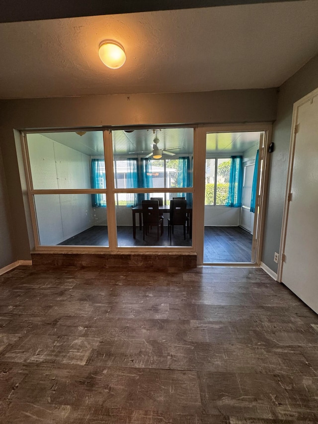 interior space featuring dark hardwood / wood-style flooring, a textured ceiling, and ceiling fan