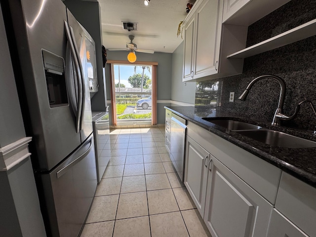 kitchen featuring sink, light tile patterned flooring, stainless steel appliances, white cabinets, and decorative backsplash