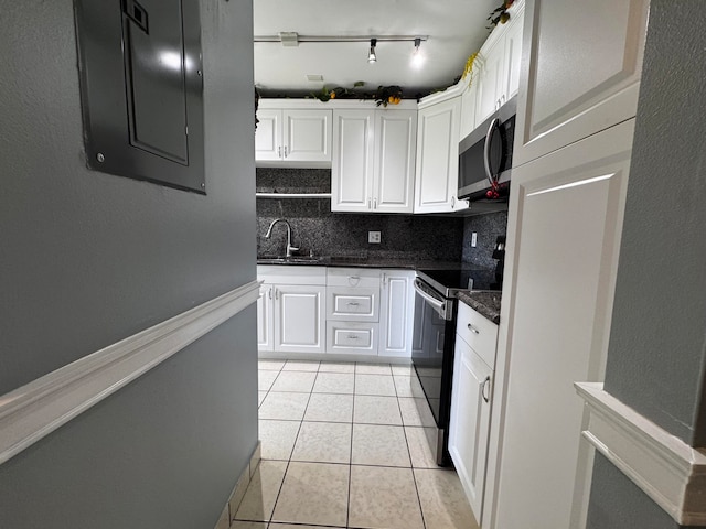 kitchen featuring tasteful backsplash, sink, stainless steel appliances, white cabinets, and light tile patterned floors