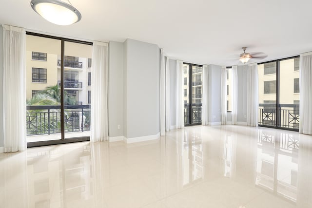 tiled empty room featuring expansive windows, ceiling fan, and plenty of natural light