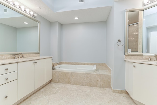 bathroom with vanity, a textured ceiling, shower with separate bathtub, and tile patterned flooring