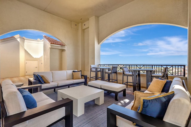 view of patio / terrace featuring a water view, a balcony, and outdoor lounge area