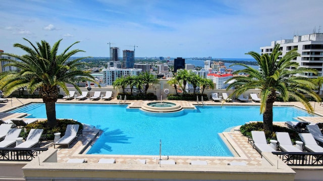 view of swimming pool with a hot tub and a patio area