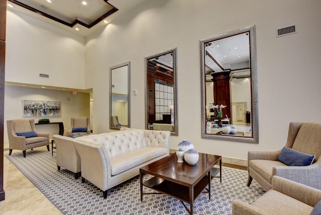 living room featuring ornate columns and a towering ceiling