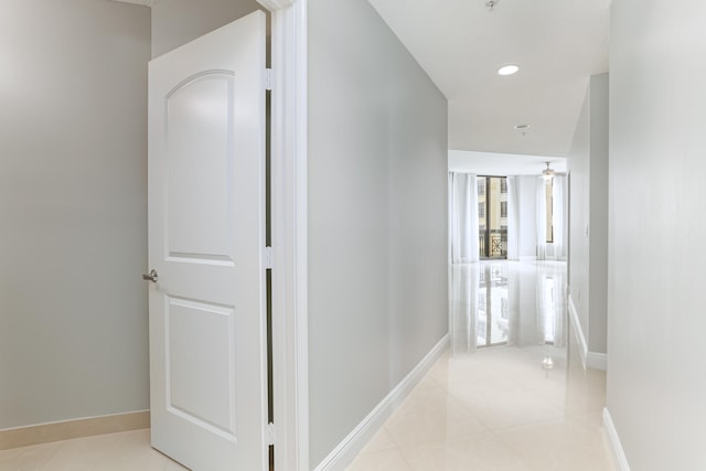 hallway featuring light tile patterned flooring and a wealth of natural light