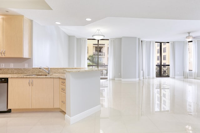 kitchen featuring light brown cabinets, light stone counters, dishwasher, light tile patterned flooring, and sink