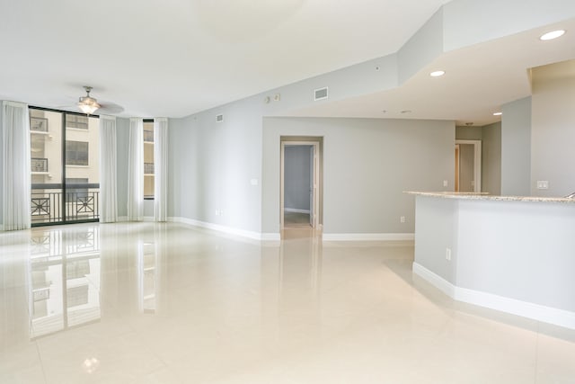 spare room with ceiling fan and light tile patterned floors