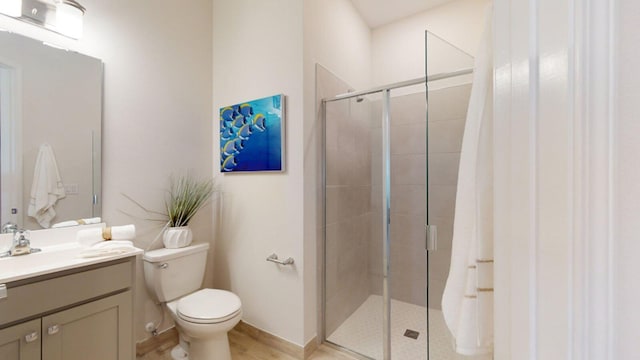 bathroom with vanity, a shower with shower door, hardwood / wood-style flooring, and toilet