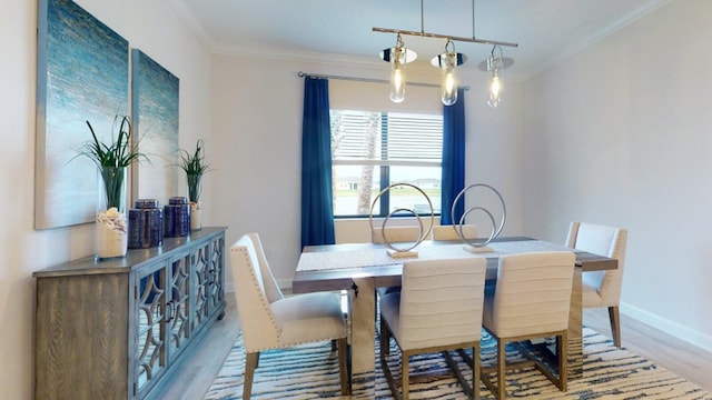 dining room with crown molding, light hardwood / wood-style flooring, and a chandelier