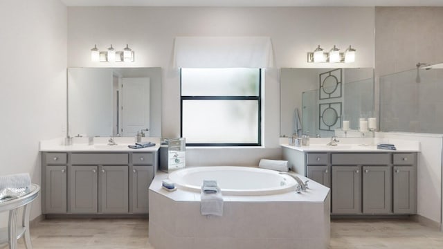 bathroom featuring vanity and a relaxing tiled tub