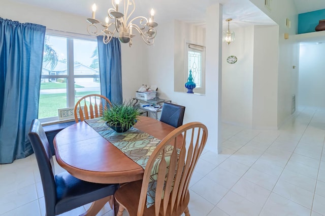 tiled dining room with an inviting chandelier and plenty of natural light