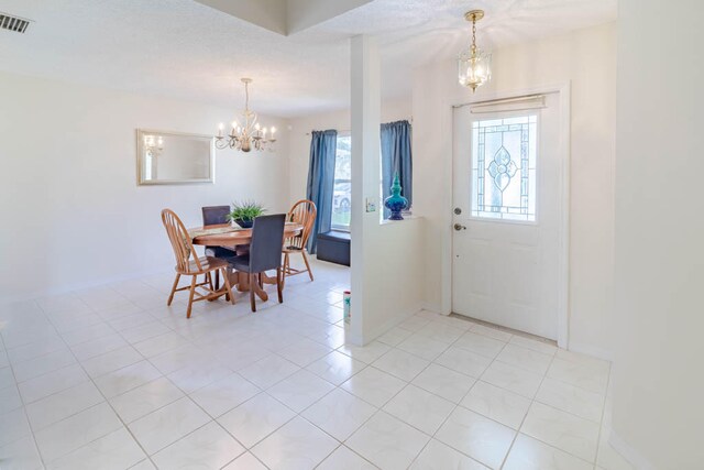 tiled foyer with a chandelier