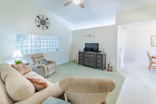 tiled living room with ceiling fan and high vaulted ceiling