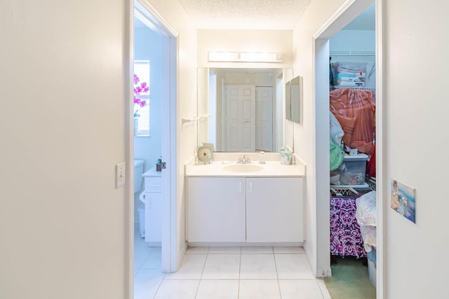 bathroom with tile patterned flooring, vanity, and a textured ceiling