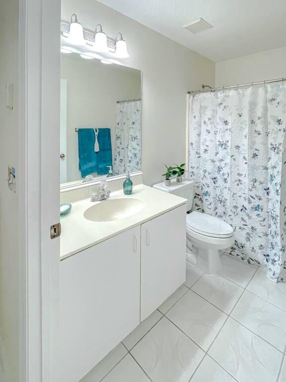 bathroom featuring tile patterned flooring, vanity, and toilet
