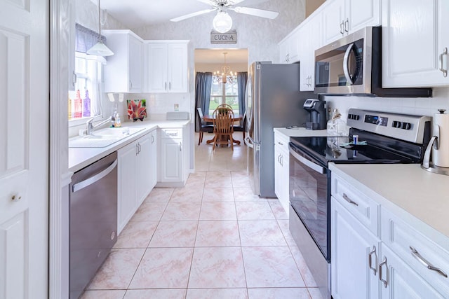kitchen with pendant lighting, white cabinetry, sink, and stainless steel appliances