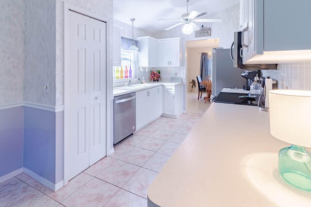 kitchen featuring sink, stainless steel appliances, white cabinetry, and light tile patterned flooring