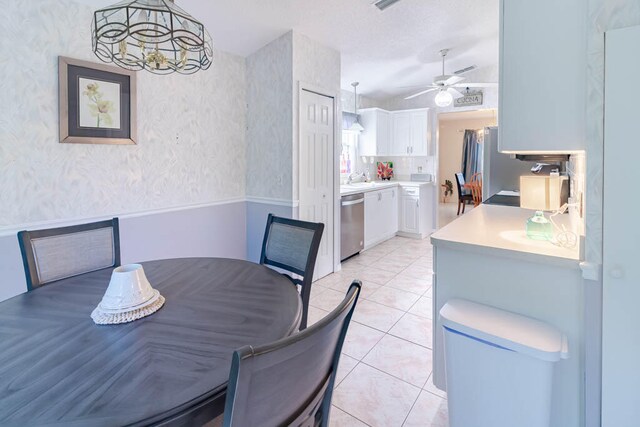 dining space featuring ceiling fan with notable chandelier and light tile patterned floors