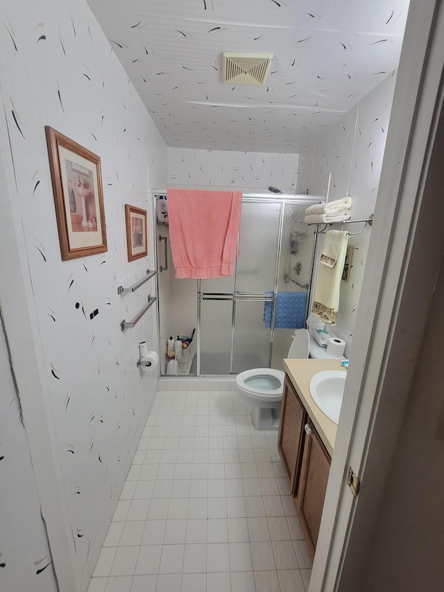 bathroom featuring vanity, toilet, tile patterned flooring, and an enclosed shower