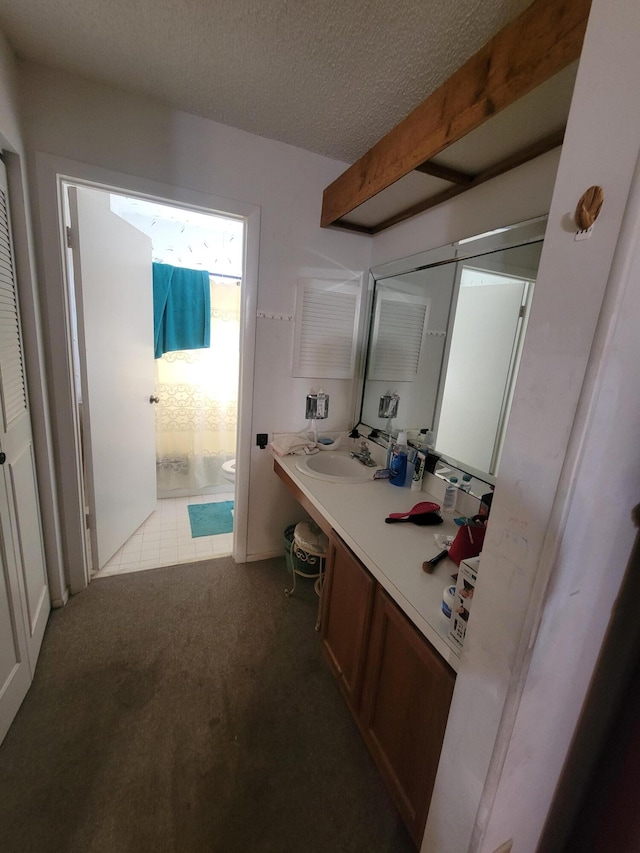 bathroom with vanity, a textured ceiling, toilet, and tile patterned floors