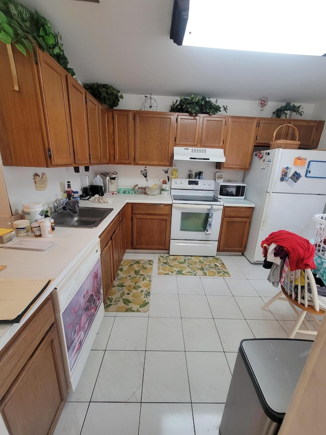 kitchen featuring light tile patterned flooring, sink, and white appliances