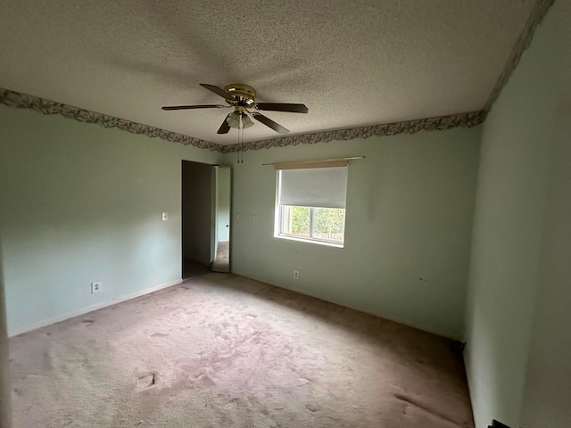 carpeted empty room featuring a textured ceiling and ceiling fan