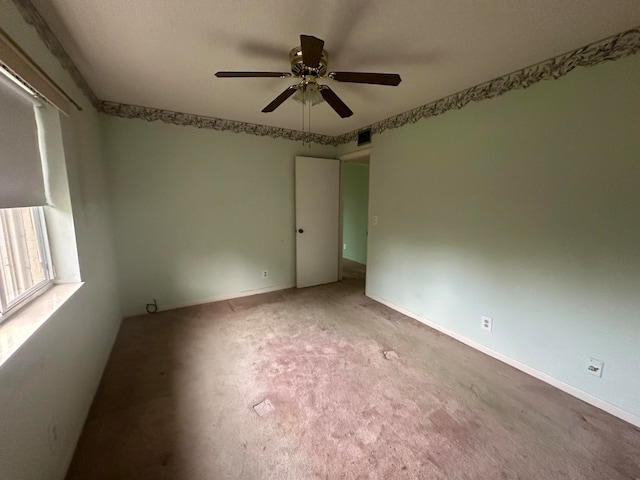 spare room with ceiling fan and light carpet