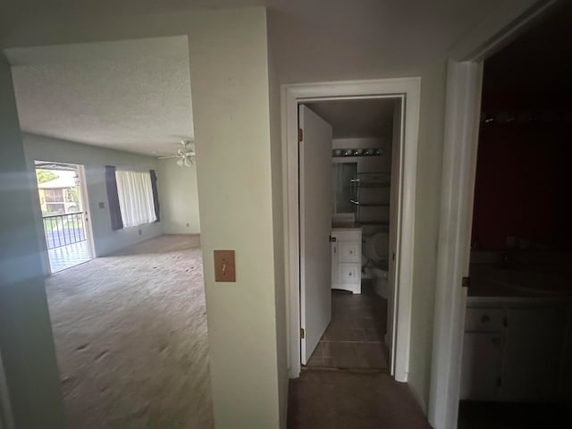 hallway featuring carpet floors and a textured ceiling