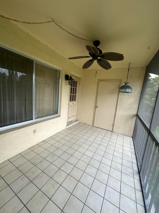 unfurnished sunroom featuring ceiling fan