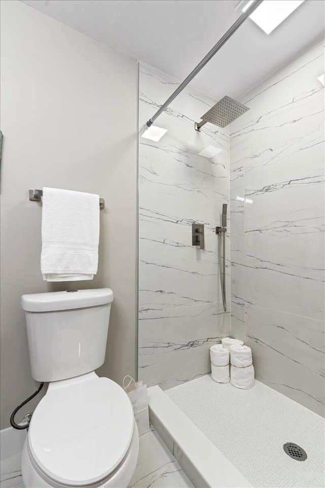 bathroom featuring toilet and a tile shower