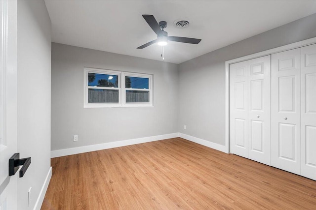 unfurnished bedroom with light hardwood / wood-style floors, a closet, and ceiling fan