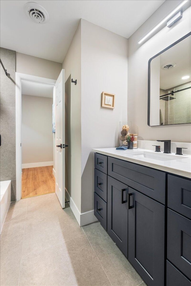 bathroom featuring vanity, hardwood / wood-style floors, and walk in shower