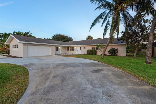 ranch-style house featuring a front lawn and a garage