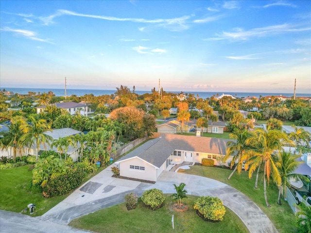 aerial view at dusk featuring a water view