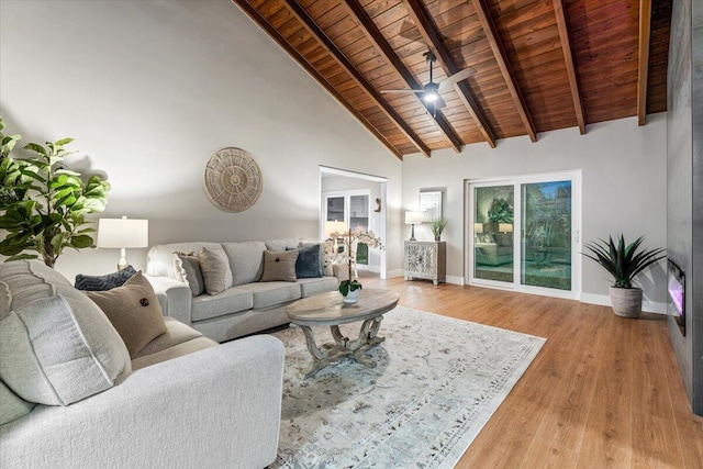 living room with light hardwood / wood-style floors, ceiling fan, wooden ceiling, beamed ceiling, and high vaulted ceiling