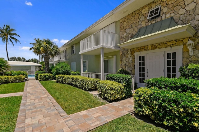 exterior space featuring a balcony and a yard