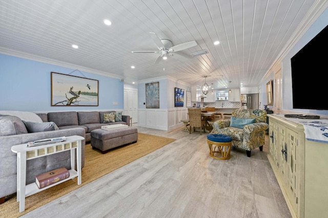 living area with recessed lighting, wainscoting, ornamental molding, light wood-type flooring, and a ceiling fan
