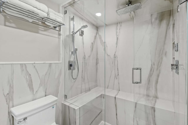 full bath featuring tile walls, toilet, and a marble finish shower