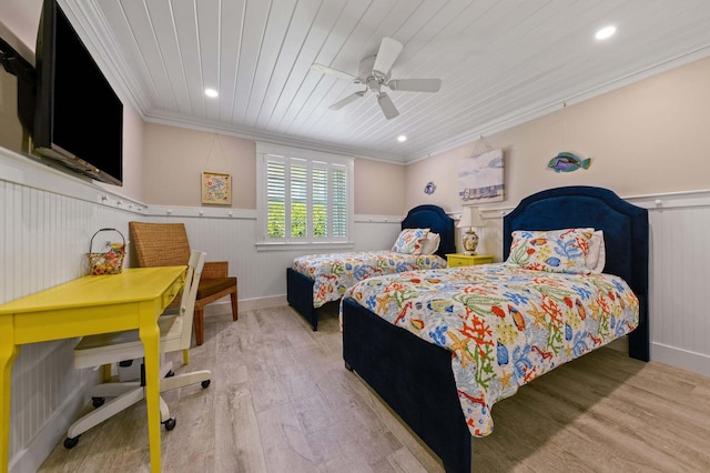 bedroom featuring wood ceiling, crown molding, wood finished floors, a ceiling fan, and wainscoting