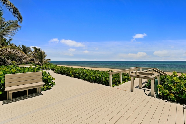 deck featuring a beach view and a water view