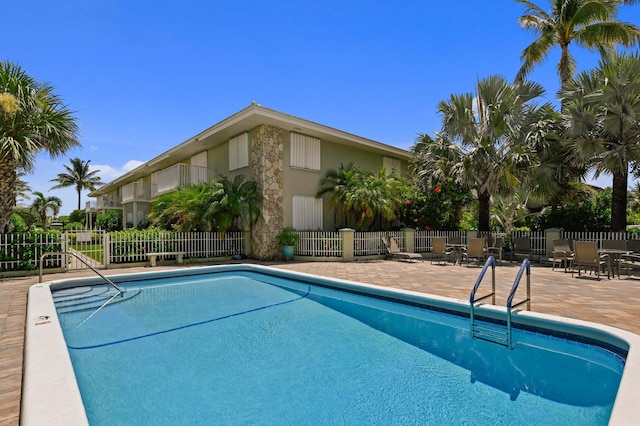 community pool featuring fence and a patio area