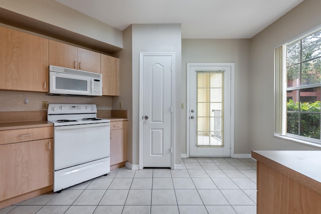 kitchen featuring light brown cabinets, light tile patterned floors, and white appliances